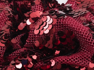 Macro shot of vibrant red sequins on mesh fabric for a sexy party dress detail