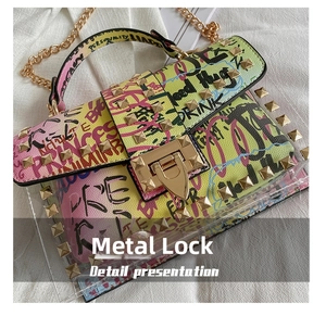 Detail of the gold hardware lock and metallic rivets on the graffiti jelly shoulder bag
