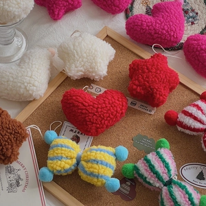 Close-up of festive plush teddy wool ornaments in heart and star shapes for DIY Christmas decor