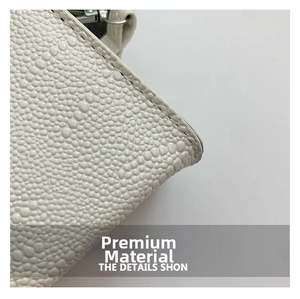 Close-up of white embossed grain faux leather texture with fine stitching and silver hardware