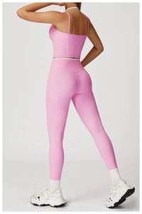 Détail de l'ensemble de yoga rose deux pièces avec haut court et legging à rayures blanches