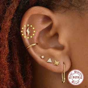 Detail of 925 sterling silver gold stud earring set showing mixed geometric shapes on ear