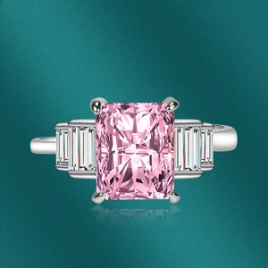 Macro shot of pink radiant-cut crystal ring with baguette accents on dark background