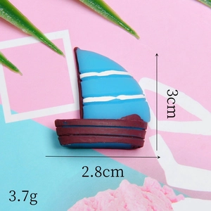 Macro view of blue and brown resin sailboat charm with 3cm x 2.8cm dimensions