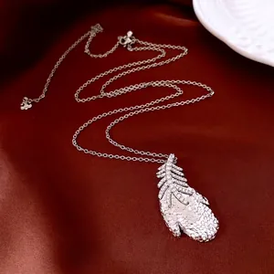 Luxury silver feather necklace with zircon crystals on premium deep red silk background