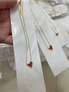 Detailed view of red heart pendant necklace in gold-plated stainless steel texture