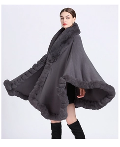Detail of dark grey knit poncho featuring a premium faux rabbit fur collar and wide fit