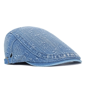 Close-up of washed blue denim newsboy cap featuring vintage distressed textures