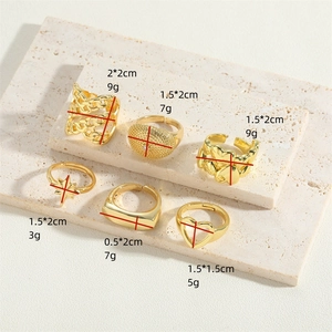 Set of 6 gold plated vintage rings with heart and star patterns on marble surface