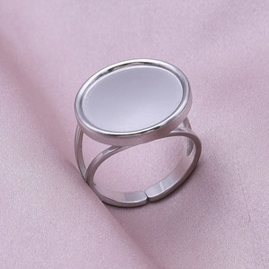 Detailed macro of a silver adjustable ring featuring a flat oval top tray on pink silk