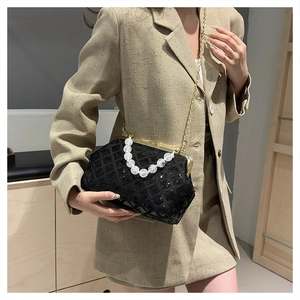 Sparkly black sequin shell bag with pearl handle worn with a khaki blazer
