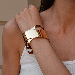 Détail d'un bracelet manchette doré à plusieurs couches avec une finition polie