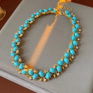 Vue macro d'un collier vintage doré avec pierres turquoise et strass scintillants