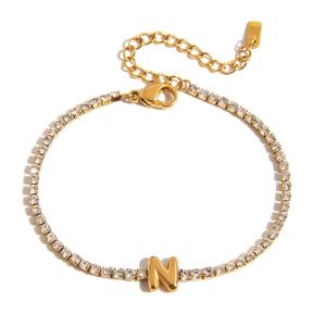 Detailed macro of 18K gold letter N charm bracelet with sparkling pave zirconia