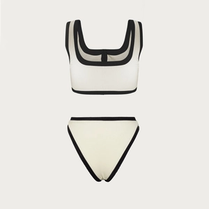 Close-up of ribbed fabric texture with black contrast piping on cream bikini set