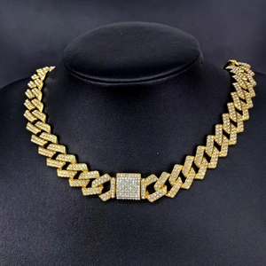 Close-up of golden 14mm Cuban chain with full diamond inlay on a black bust display