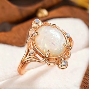 Vintage rose gold ring featuring a colorful oval opal stone in a bohemian hollow design