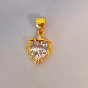 Macro shot of gold-plated heart pendant with centered zircon and halo crystal settings