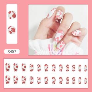 Detail view of R457 almond press-on nails with pink cow print pattern and set layout