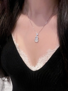 Close-up of a stainless steel gourd pendant necklace with zircon and translucent stone