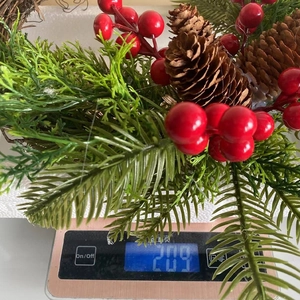 Close-up detail of a farmhouse bohemian Christmas wreath on a scale weighing 209 grams