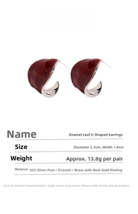 Detailed view of burgundy enamel C-shaped leaf earrings with brass gold-plated finish