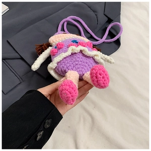 Close-up of handmade purple knitted crossbody bag featuring a cute 3D doll design