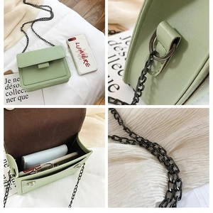 Detail view of mini green PU leather crossbody bag featuring black metal chain and compartments