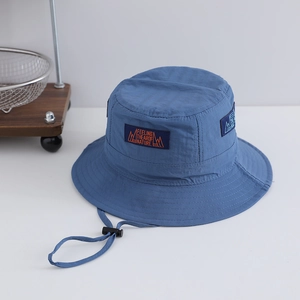 Detail of navy sun hat featuring mountain patch and adjustable windproof strap