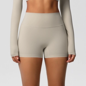 Detail of high-waist yoga shorts in light beige fabric showing soft texture and fit