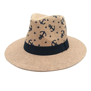 Classic summer straw fedora hat featuring blue anchor prints and black ribbon band for beach