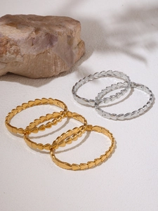 Close-up of interlocking heart-shaped link bracelets in gold and silver finishes