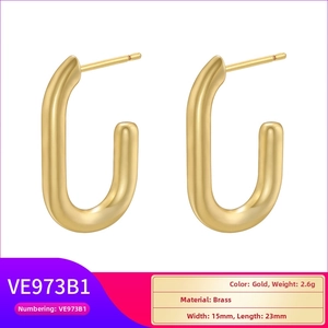 Detailed macro view of gold-plated brass U-shaped earrings with brushed texture