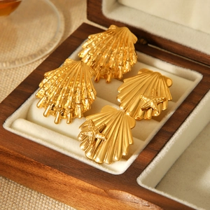 Detailed shot of 18k gold starfish and shell earrings in a velvet wooden jewelry box