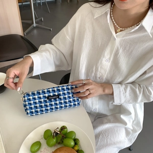 Gros plan sur la trousse en tissu à carreaux bleus et blancs avec étiquette tissée