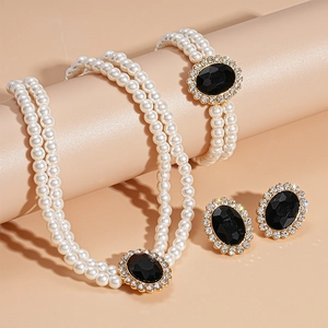 Close-up of vintage faux pearl jewelry set with black oval stones and crystal accents