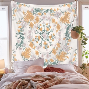 Detailed view of floral mandala tapestry hanging above a cozy bed with natural light