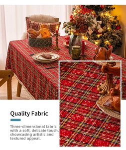 Close-up of red plaid Christmas tablecloth with snowflake patterns and pom-pom fringe