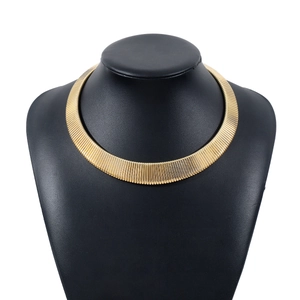 Exaggerated wide gold ribbed choker necklace for women on a black bust mannequin display