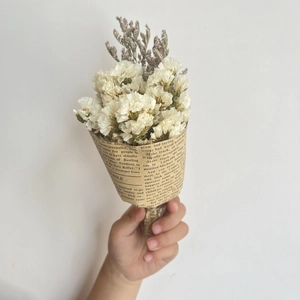 Mini dried flower bouquet with white baby's breath and purple accents in kraft paper