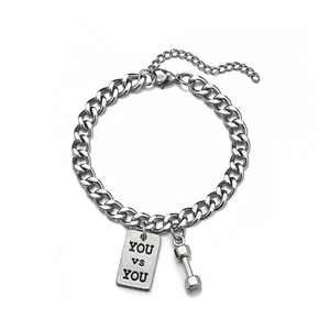 Close-up of dumbbell and YOU VS YOU engraved tags on a silver Cuban link bracelet