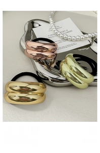 Three premium metallic hair ties in rose gold and gold finishes on a silver tray