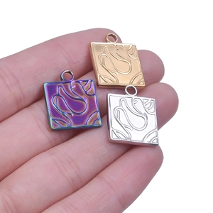 Macro detail of square stainless steel charms with abstract texture for DIY jewelry