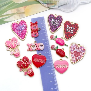 Détail de breloques en émail rouge et rose avec règle violette pour mesurer la taille