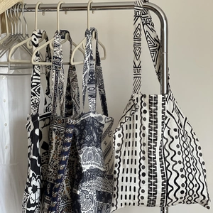 Détails de sacs cabas en lin bohème avec motifs tribaux ethniques sur des cintres