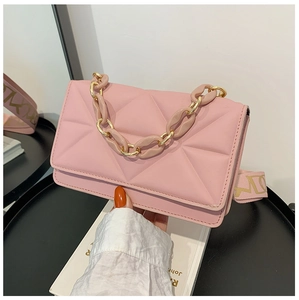 Detailed macro view of pink quilted texture with thick plastic chain on a trendy crossbody bag