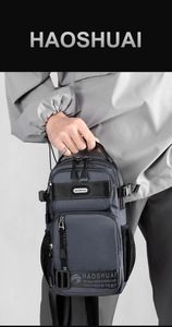 Close-up of grey waterproof nylon crossbody bag with multi-layer zippers and side mesh pocket