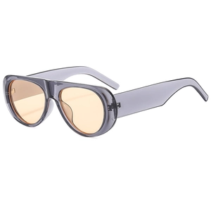 Close-up of vintage pilot sunglasses with transparent grey frame and orange lenses