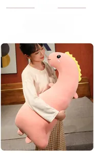 Close-up of long pink plush dinosaur pillow featuring soft fabric and yellow fin details