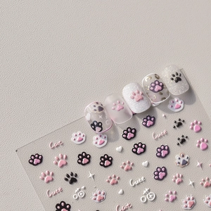 Macro shot of 3D embossed cat paw and heart nail art stickers with glitter finish